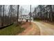 Two-story home with dormer windows surrounded by trees and a long concrete driveway at 255 Olde Oak Dr, Jonesboro, GA 30238