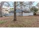 Spacious backyard featuring trees, grass, and a grey brick and siding house at 554 Sherwood Oaks Rd, Stone Mountain, GA 30087