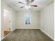 Bedroom features neutral carpet, a ceiling fan, and natural light from a window at 554 Sherwood Oaks Rd, Stone Mountain, GA 30087