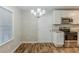 Bright dining room features modern chandelier and wood floors right next to kitchen at 554 Sherwood Oaks Rd, Stone Mountain, GA 30087