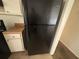 Close-up of a black fridge with white cabinets and wood countertops at 5676 Marbut Rd, Lithonia, GA 30058