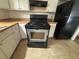 Close-up of a black range oven in kitchen with white cabinets at 5676 Marbut Rd, Lithonia, GA 30058