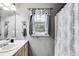 Bathroom featuring a vanity sink, a window, and a bathtub with a shower curtain for privacy at 2960 Paul Harris Rd, Dallas, GA 30157