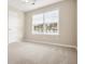 This bedroom has neutral walls and carpet, white door, and a window that lets in plenty of natural light at 37 Jekyll Dr, Marietta, GA 30066