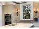 Bright kitchen featuring stainless steel appliances, mosaic backsplash and sconce lighting around the large window at 81 Peachtree Ne Cir, Atlanta, GA 30309