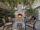 Backyard stone fireplace with seating area offering a cozy outdoor gathering space amidst lush greenery at 121 17Th Ne St, Atlanta, GA 30309
