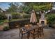 Backyard patio with an outdoor dining set, an umbrella, and a stone fireplace surrounded by manicured greenery at 121 17Th Ne St, Atlanta, GA 30309