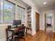 Bright office nook with built-in bookshelves, a desk, and hardwood floors at 121 17Th Ne St, Atlanta, GA 30309