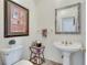 Stylish powder room featuring a pedestal sink, decorative mirror, and elegant decor at 1279 Saxony Se Dr, Conyers, GA 30013