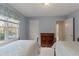 Bright bedroom featuring two beds, natural light, a wooden dresser, and light-blue painted walls at 17 Vickers Pl, Douglasville, GA 30134