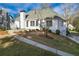 Back exterior view with a brick patio, sunroom with a roof, and a manicured lawn at 17 Vickers Pl, Douglasville, GA 30134