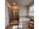 Bright bathroom featuring a shower, tub, and storage with a window providing plenty of natural light at 1935 Manor Pointe Dr, Cumming, GA 30041