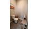 Neutral powder room featuring tile flooring, a modern toilet, and a stylish vanity with a desert landscape art piece at 1935 Manor Pointe Dr, Cumming, GA 30041