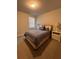 A cozy bedroom featuring carpet floors, a window with blinds, neutral walls, and a comfortable bed with decorative pillows at 1935 Manor Pointe Dr, Cumming, GA 30041