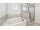 Bathroom featuring a tiled shower and tub combo with a small window and neutral tile at 2808 Blandwood Rd, Marietta, GA 30064