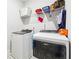 Functional laundry room with a washer and dryer set, complemented by storage shelves and a white tiled floor at 2808 Blandwood Rd, Marietta, GA 30064