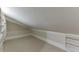 Cozy attic space with neutral carpet, built-in shelves, and slanted ceilings creating a unique storage or bonus area at 3980 Saint Elisabeth Sq, Duluth, GA 30096