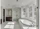 Bright bathroom featuring a soaking tub, a glass-enclosed shower, and abundant natural light at 3980 Saint Elisabeth Sq, Duluth, GA 30096