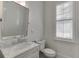 Cozy bathroom with marble countertop vanity, framed mirror, and a window providing natural light at 3980 Saint Elisabeth Sq, Duluth, GA 30096