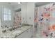 Well-lit bathroom features white vanity, granite countertop, and a floral shower curtain at 3980 Saint Elisabeth Sq, Duluth, GA 30096