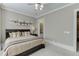 Neutral bedroom features a large bed, airplane art, and a door leading to another room at 3980 Saint Elisabeth Sq, Duluth, GA 30096