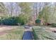 Picturesque backyard featuring a fire pit surrounded by lush greenery and a stone path at 3980 Saint Elisabeth Sq, Duluth, GA 30096