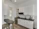 Charming kitchenette with white cabinets, black countertops and stainless steel appliances, perfect for modern living at 3980 Saint Elisabeth Sq, Duluth, GA 30096