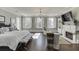 The main bedroom with a fireplace, TV, three windows, and an ornate chandelier at 3980 Saint Elisabeth Sq, Duluth, GA 30096