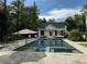Private backyard oasis with a sparkling pool, hot tub, striped umbrella, and landscaping perfect for relaxing and entertaining at 3980 Saint Elisabeth Sq, Duluth, GA 30096