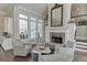 Sunlit sitting area showcases fireplace with stone surround, comfortable seating, and dark hardwood floors at 3980 Saint Elisabeth Sq, Duluth, GA 30096