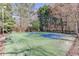 Outdoor tennis court surrounded by trees and greenery, perfect for recreational enjoyment at 3980 Saint Elisabeth Sq, Duluth, GA 30096