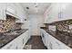 Well-lit kitchen with white cabinets, dark countertops and tiled backsplash at 903 Bridge Se Ln, Smyrna, GA 30082