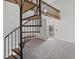 Bright living room featuring a unique spiral staircase, neutral carpeting, and an open doorway to the outside at 903 Bridge Se Ln, Smyrna, GA 30082