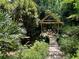 Picturesque backyard retreat with a wooden gazebo and stepping stone pathway amidst lush foliage at 1263 Briarcliff Ne Rd, Atlanta, GA 30306