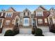 Desirable brick townhome with bay window, one car garage, front door wreath, and manicured bushes at 1286 Creekside Se Ter, Smyrna, GA 30082