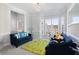 Bright living room with neutral walls, bay window, and stylish blue sofas over a green rug at 1286 Creekside Se Ter, Smyrna, GA 30082