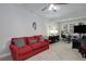 Living room with neutral carpet, bright red couch, and a ceiling fan at 1286 Creekside Se Ter, Smyrna, GA 30082