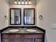 Bathroom featuring double sinks with dark cabinets and framed mirrors at 1465 Forest Brook Trl, Cumming, GA 30041