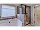 Corner soaking tub and glass shower in a bright primary bathroom, illuminated by natural light at 1465 Forest Brook Trl, Cumming, GA 30041