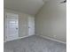 Bedroom boasts vaulted ceiling, neutral paint and carpet, and multiple doors at 1465 Forest Brook Trl, Cumming, GA 30041