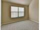 A bedroom with a large window for plenty of light and neutral paint and carpet at 1465 Forest Brook Trl, Cumming, GA 30041