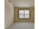 A bedroom with neutral carpet and paint, and a large window for natural light at 1465 Forest Brook Trl, Cumming, GA 30041