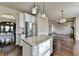 Open kitchen with stainless appliances and granite island leads to living and dining areas at 1465 Forest Brook Trl, Cumming, GA 30041