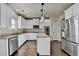 Open-concept kitchen with white cabinets, an island, granite countertops, and stainless steel appliances at 1465 Forest Brook Trl, Cumming, GA 30041