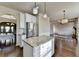 Bright kitchen with stainless steel appliances and an island featuring granite countertops and stylish pendant lighting at 1465 Forest Brook Trl, Cumming, GA 30041