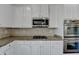 Close-up of a gourmet kitchen with white cabinetry, stainless steel appliances, and granite countertops at 1465 Forest Brook Trl, Cumming, GA 30041