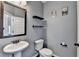 Stylish powder room features a pedestal sink, decorative mirror, and modern fixtures at 1465 Forest Brook Trl, Cumming, GA 30041