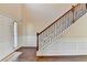 View of the home's staircase with decorative iron spindles, carpeted steps, and wood floors at 1465 Forest Brook Trl, Cumming, GA 30041