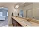 Bright bathroom featuring a double vanity with stone countertops and a large mirror reflecting the open doorway to the bedroom at 875 Olmsted Ln, Duluth, GA 30097