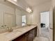 Bright bathroom featuring a double vanity with stone countertops, dark wood cabinets, and a large mirror at 875 Olmsted Ln, Duluth, GA 30097